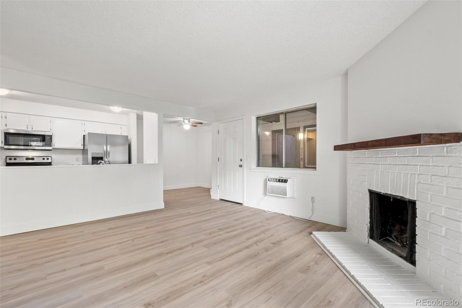 a view of a livingroom with wooden floor and a fireplace