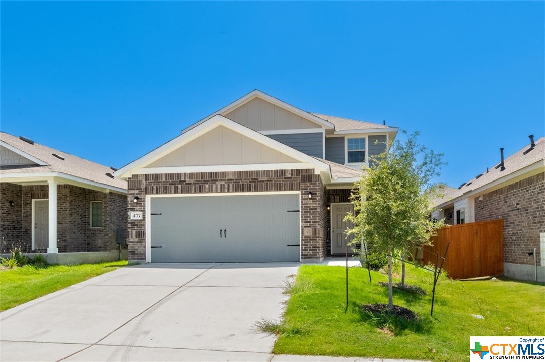 a view of a house with a yard and a garage