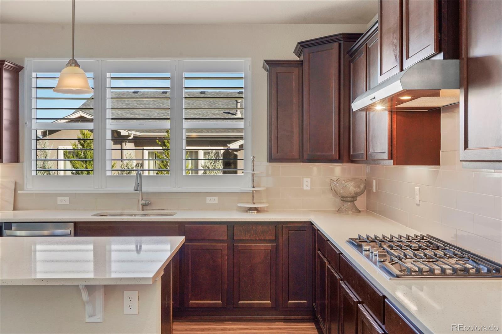 a kitchen with stainless steel appliances granite countertop a sink a stove and a wooden cabinets