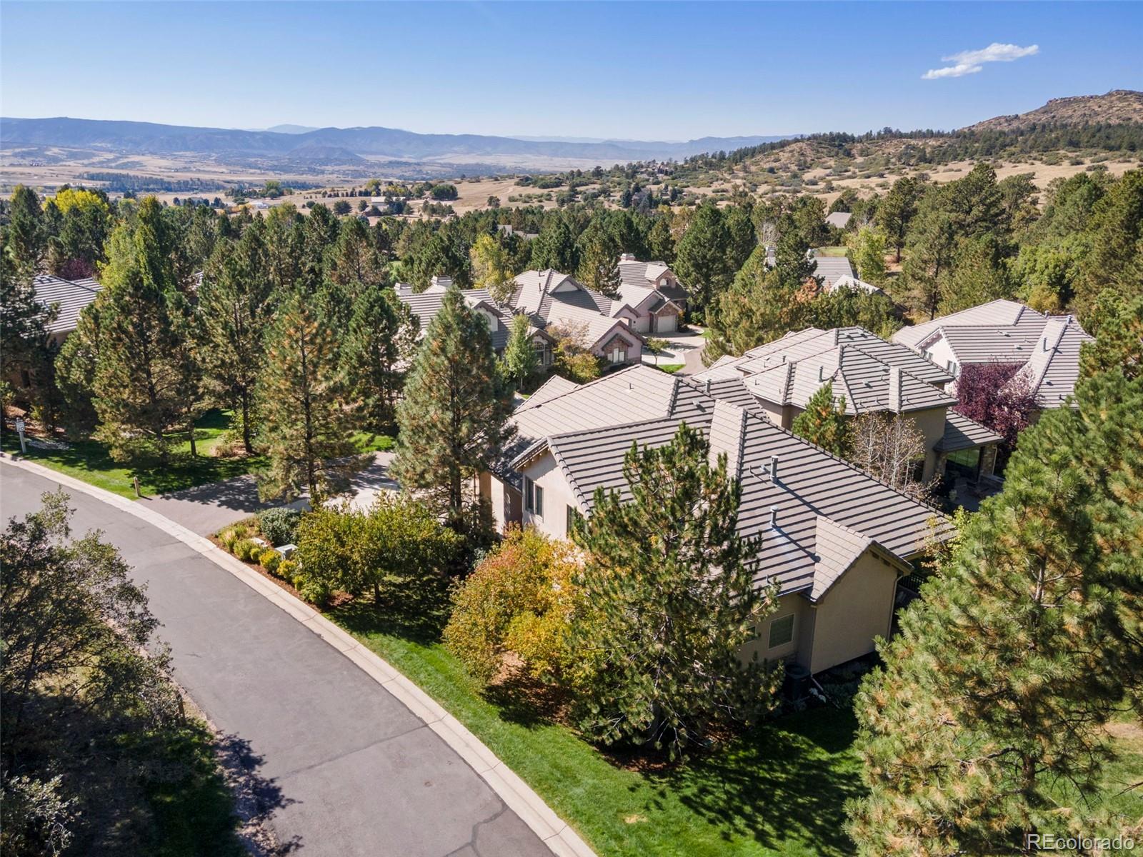 an aerial view of residential houses with outdoor space and trees