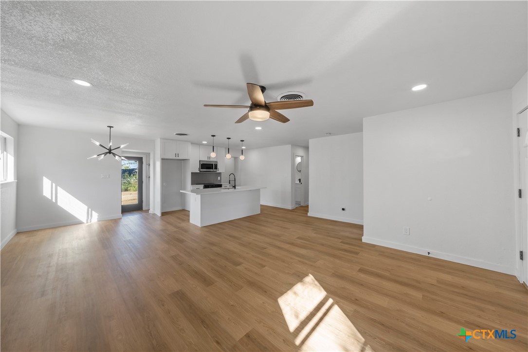 a view of a living room a wooden floor and a ceiling fan