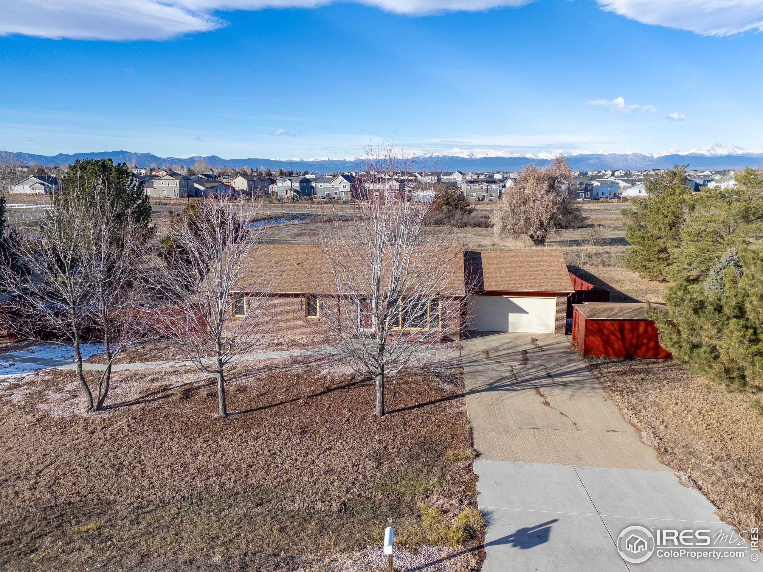 an aerial view of a house with a yard and wooden fence