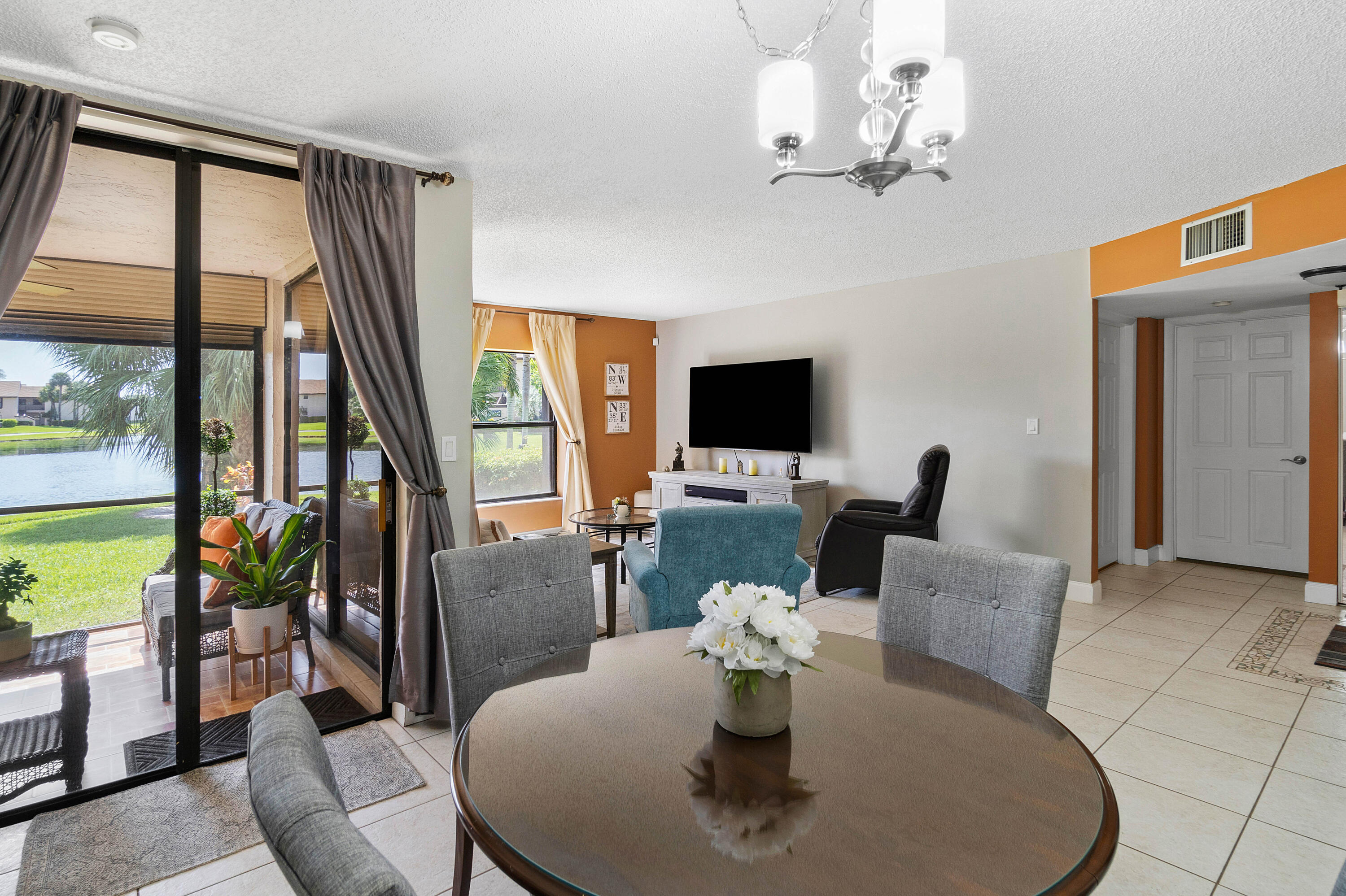 a living room with furniture a flat screen tv and a large window