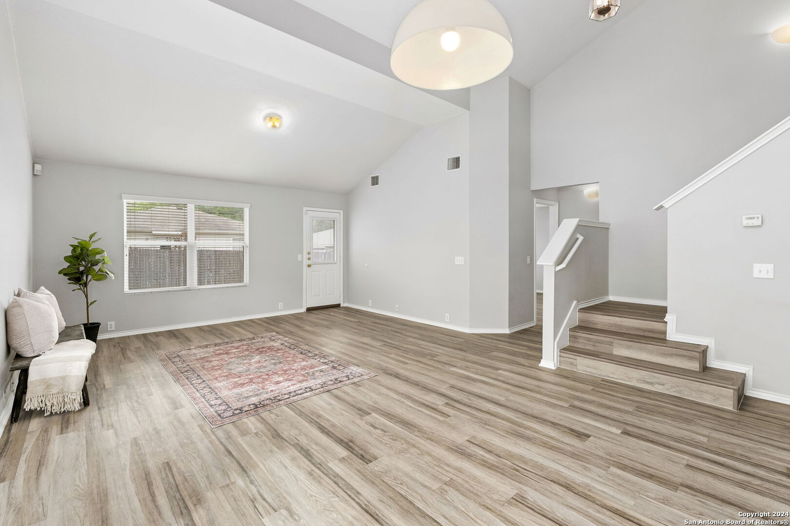 a view of a livingroom with wooden floor and a large window