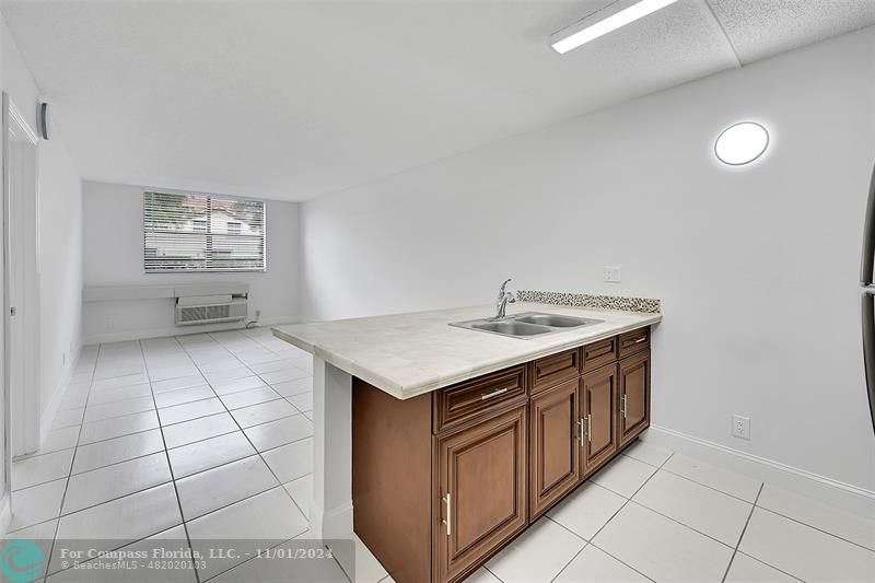 a kitchen with a sink a stove cabinets and a window