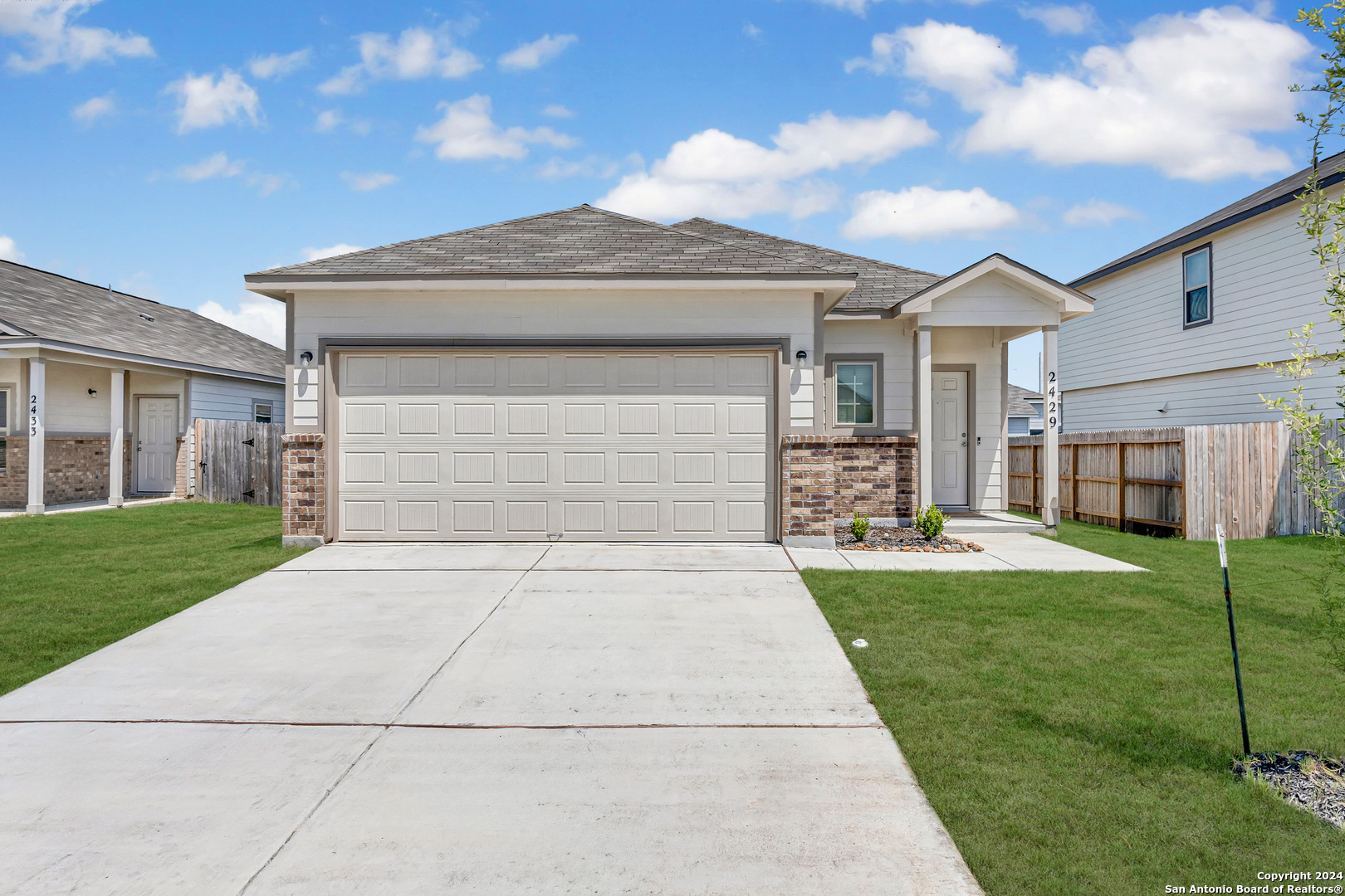 a front view of a house with a yard and garage