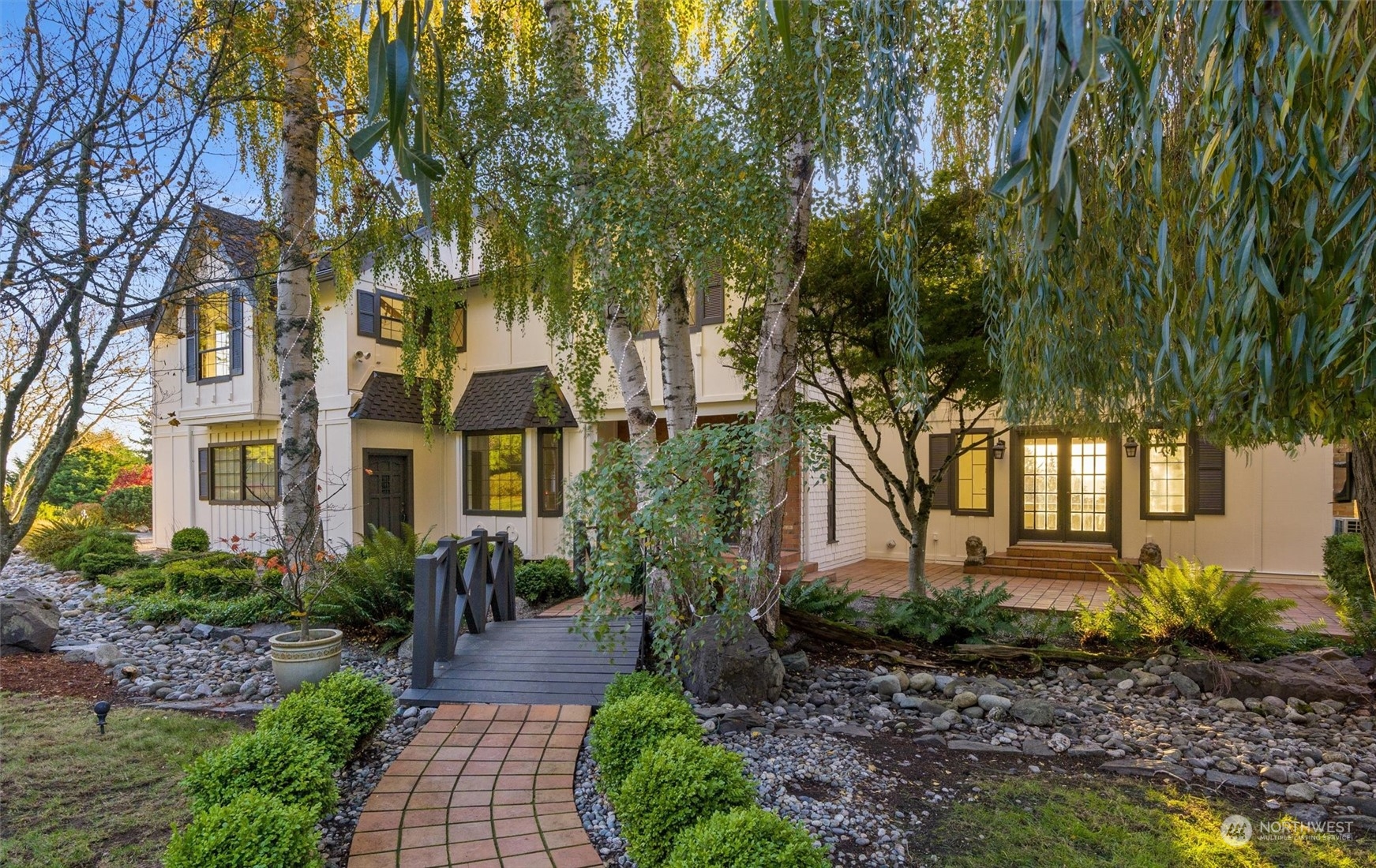 a front view of a house with garden and plants