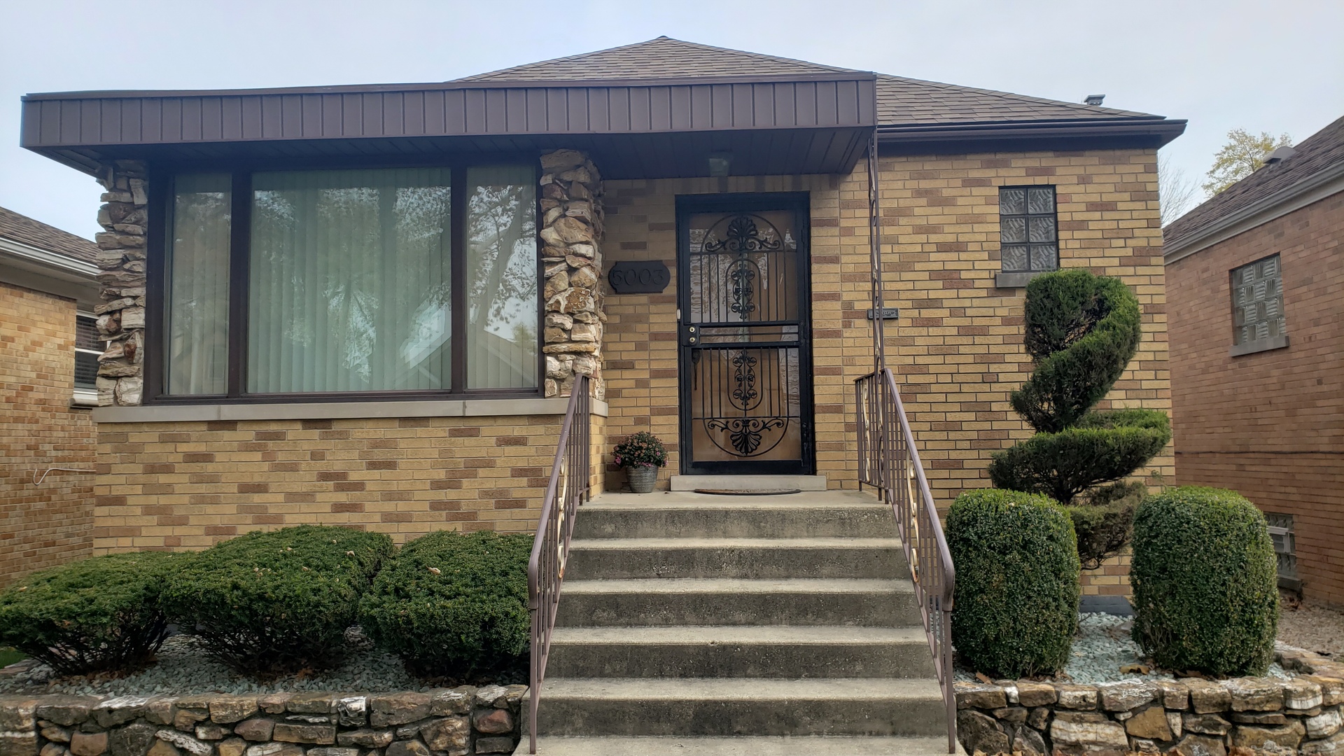 a front view of a house with plants