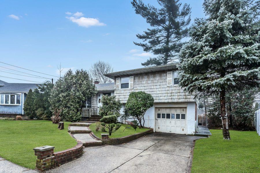 View of front of property featuring a front yard and a garage