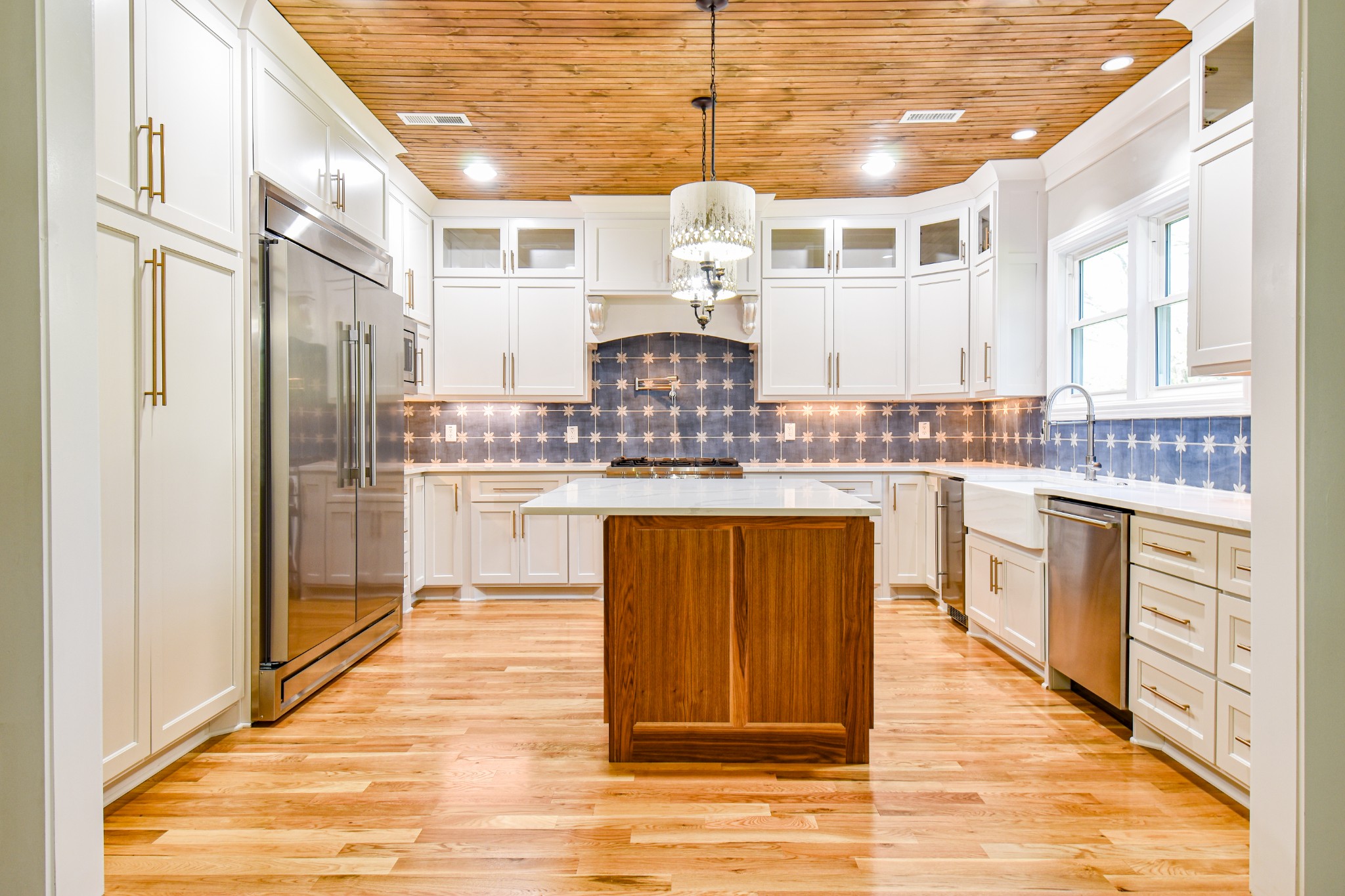 a kitchen with kitchen island granite countertop wooden cabinets and white appliances