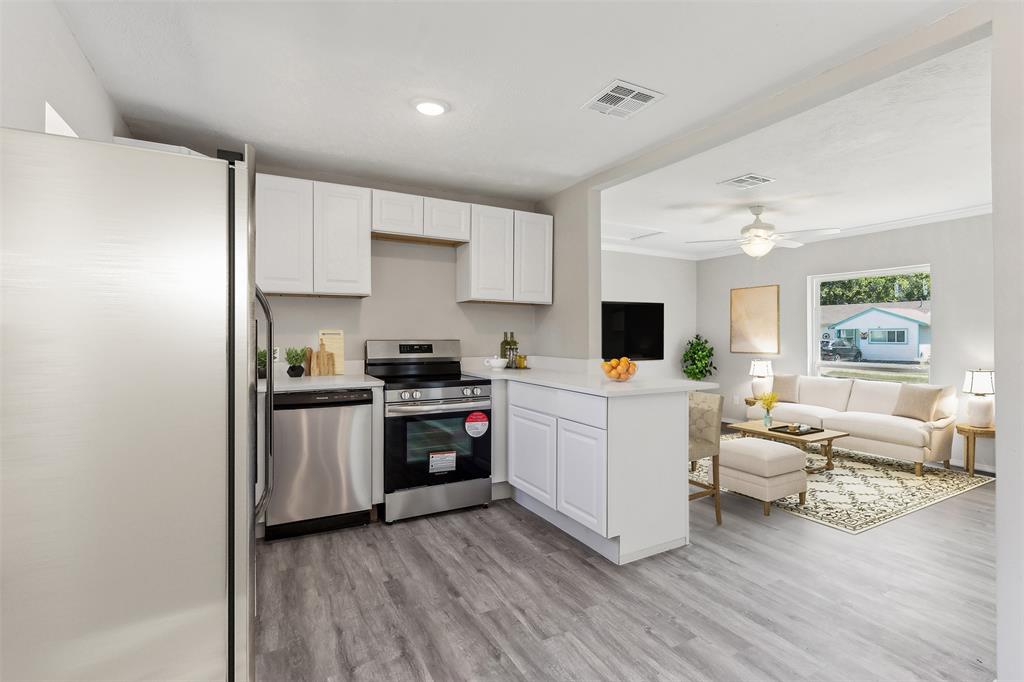 a kitchen with a refrigerator microwave and stove top oven