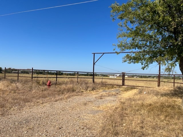 a view of a yard with wooden fence