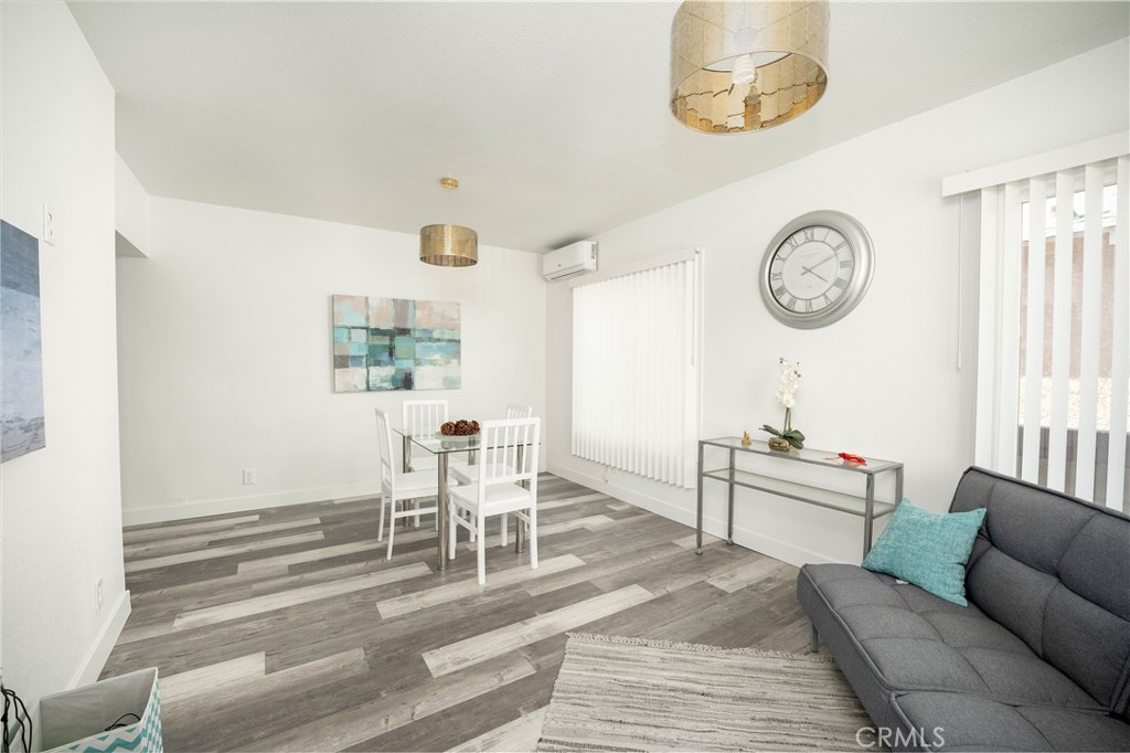 a living room with furniture a clock on wall and a window