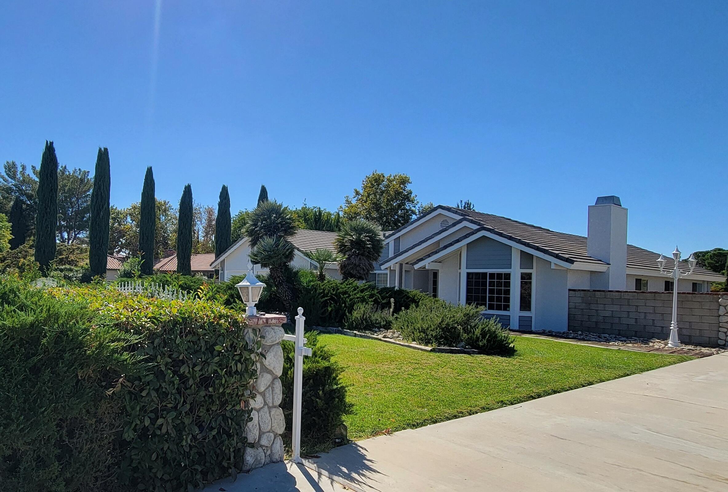 a view of a garden with a house in the background