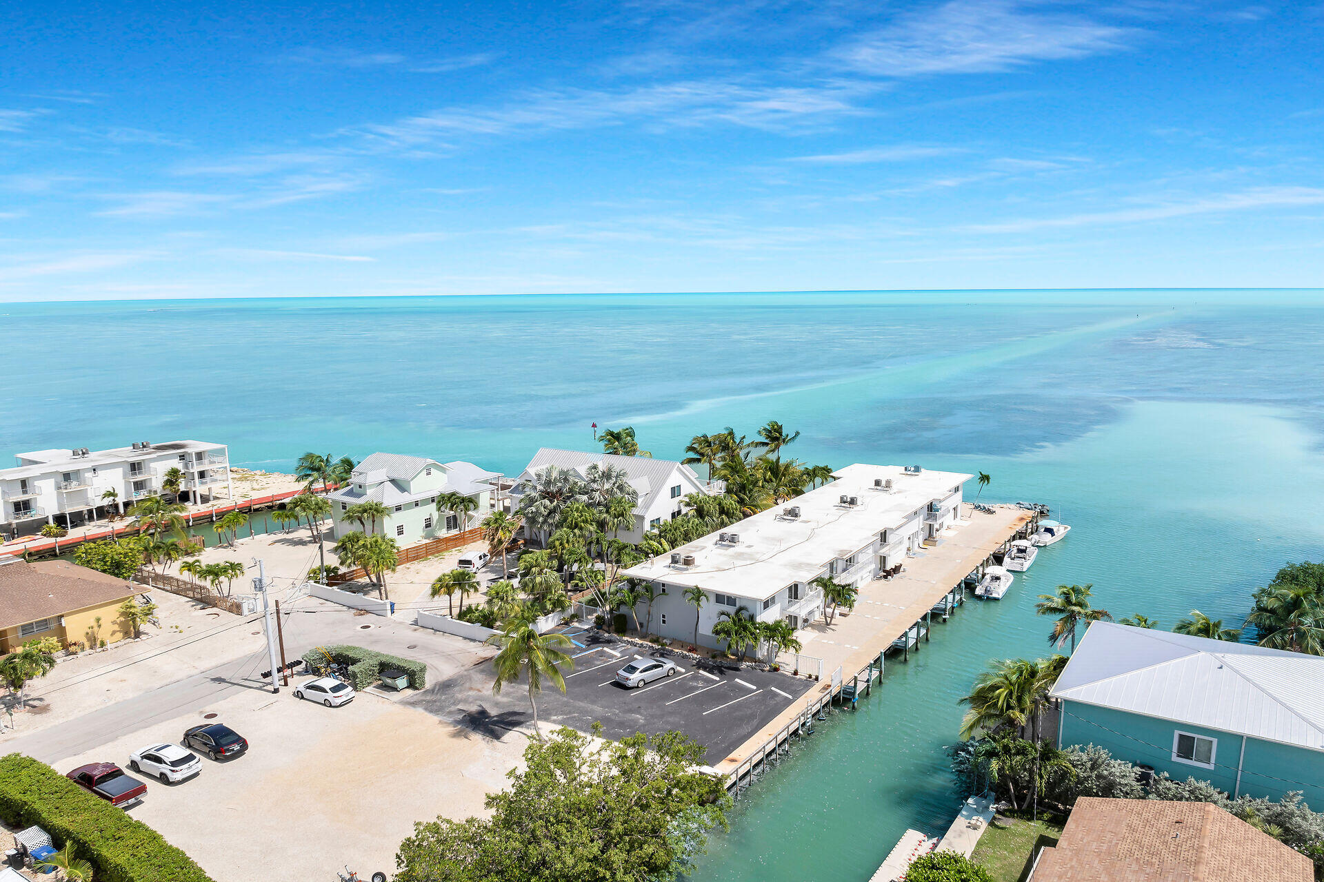 an aerial view of ocean and residential houses with outdoor space