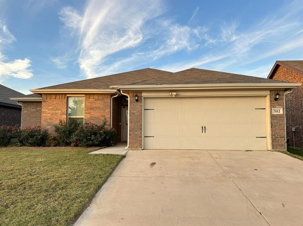 Single story home featuring a front yard and a garage