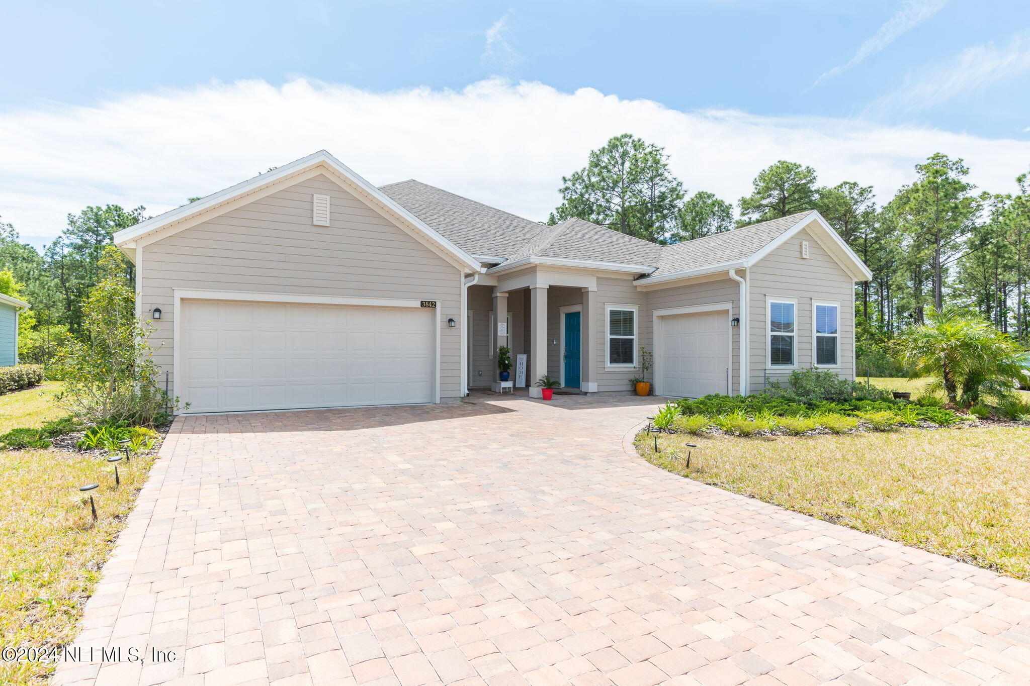 a front view of a house with a garden and yard