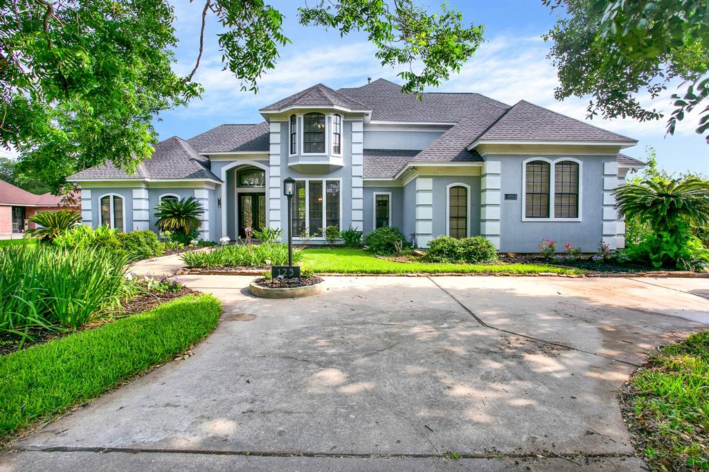 a front view of a house with yard and green space