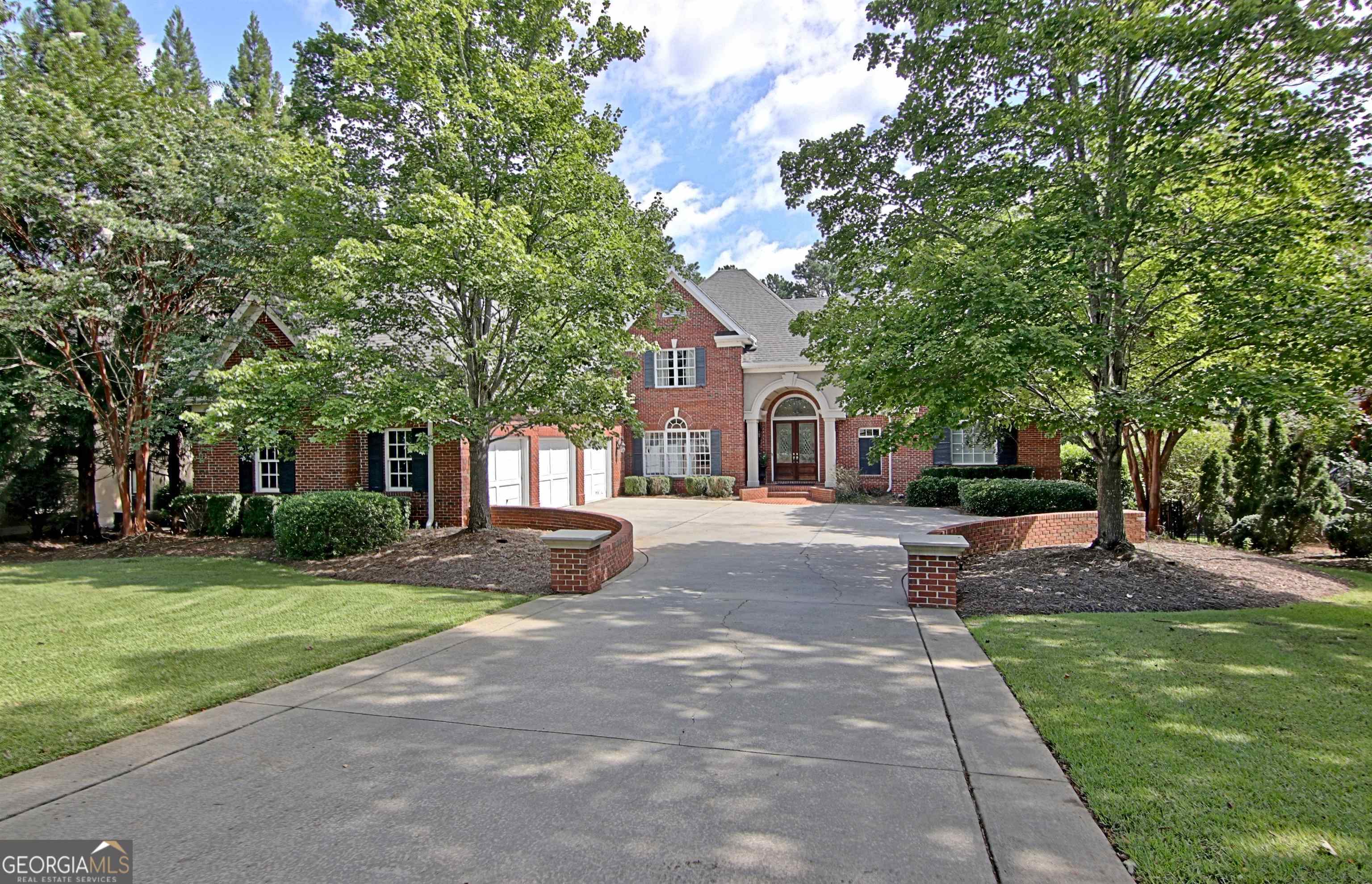 a front view of a house with a yard and trees