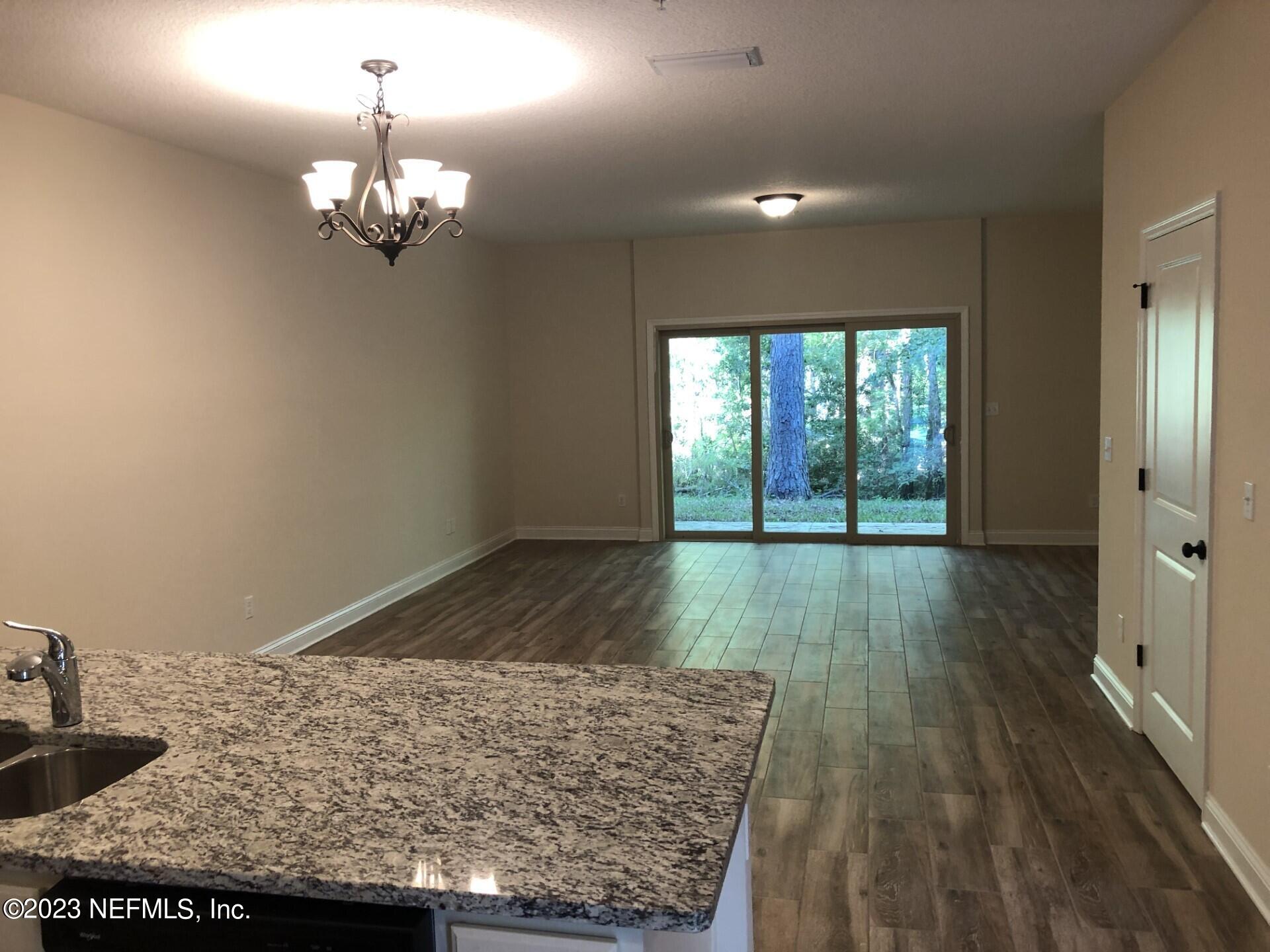 a view of a room wooden floor and kitchen view