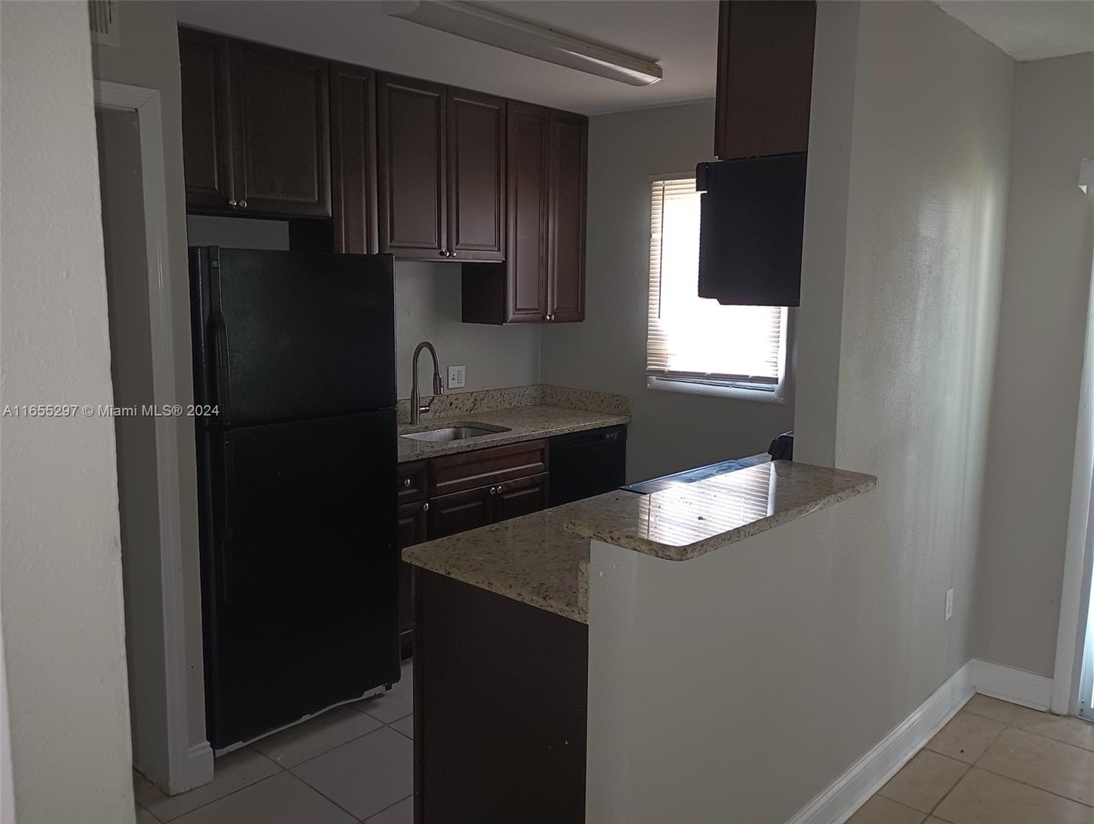 a kitchen with a refrigerator and cabinets