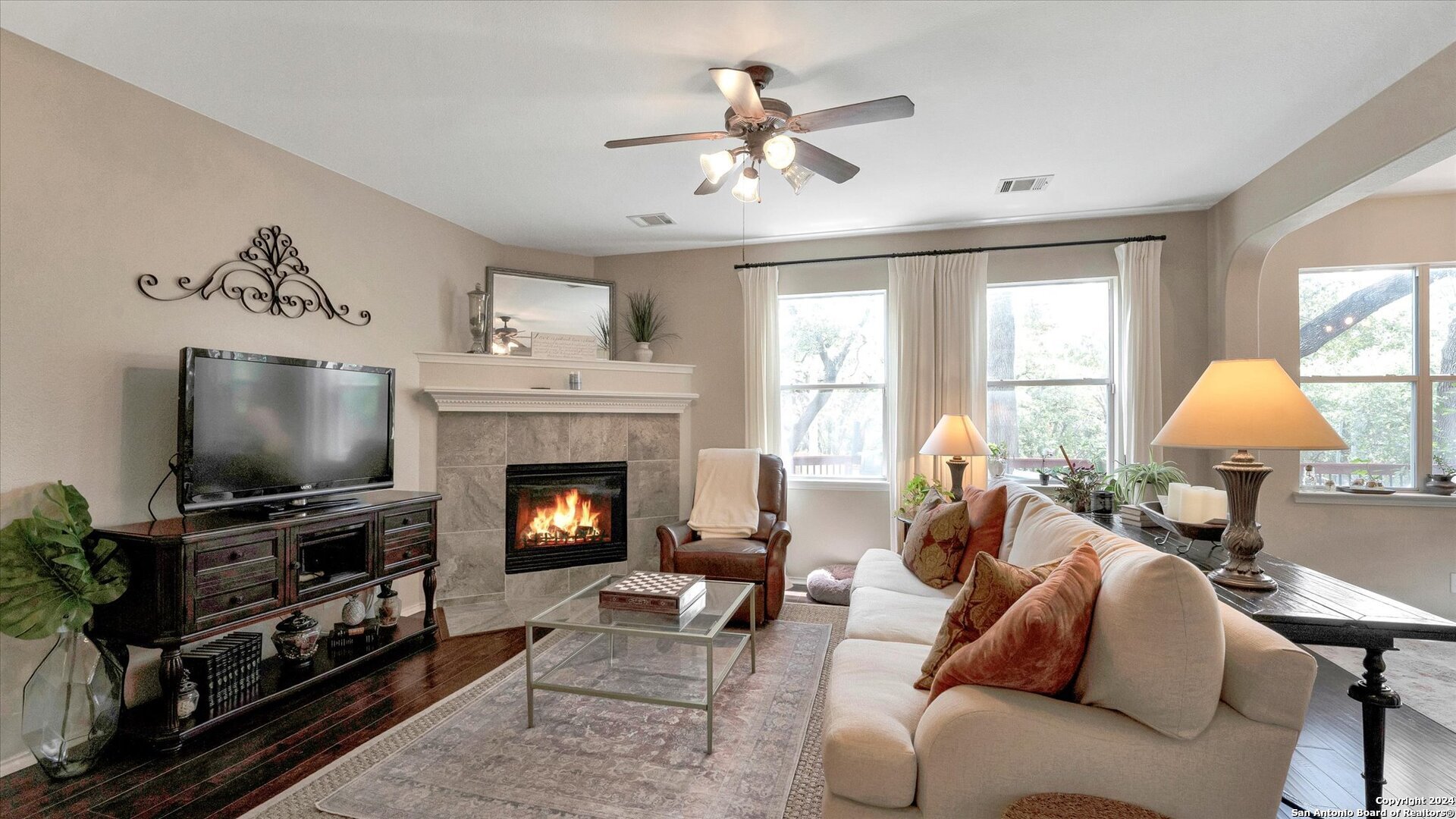 a living room with furniture a fireplace and a flat screen tv