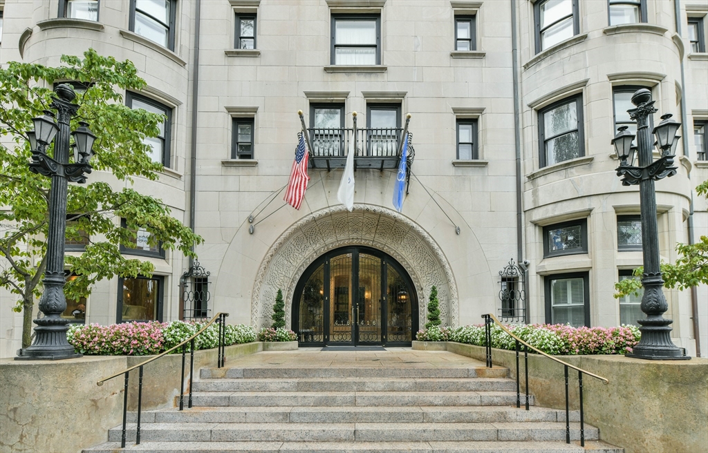 a front view of a building with garden and entryway