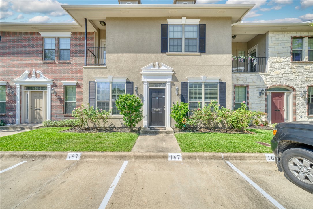 front view of a brick house with a yard