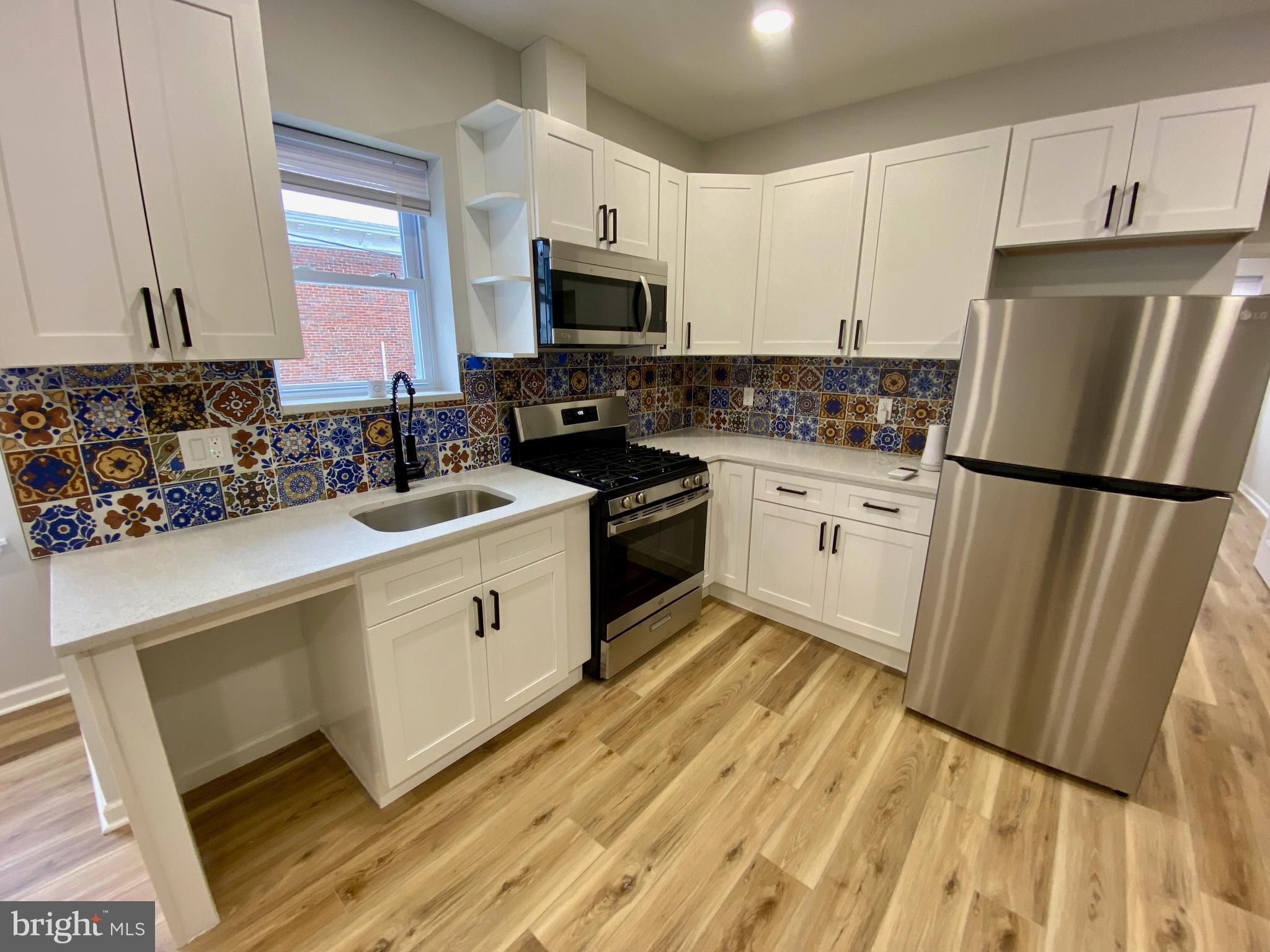 a kitchen with white cabinets and white appliances