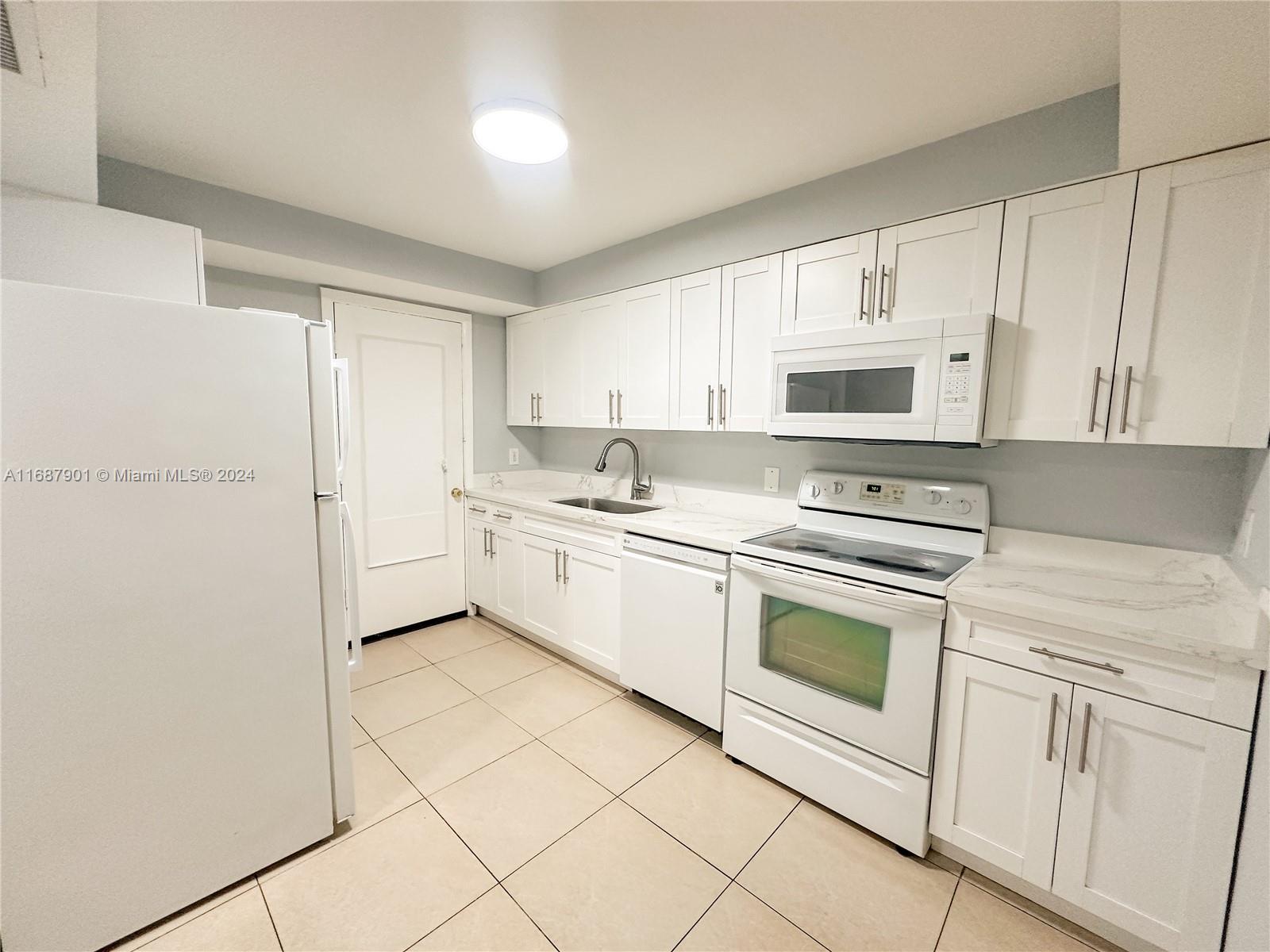 a kitchen with cabinets stainless steel appliances and sink