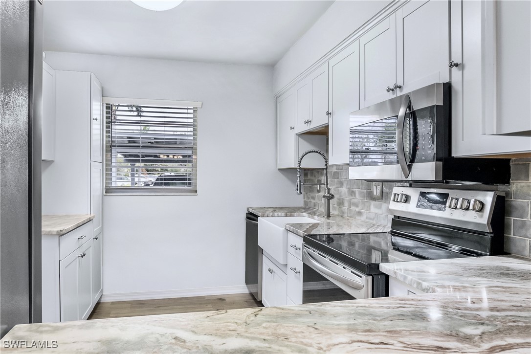 a kitchen with stainless steel appliances granite countertop a stove a sink and a microwave