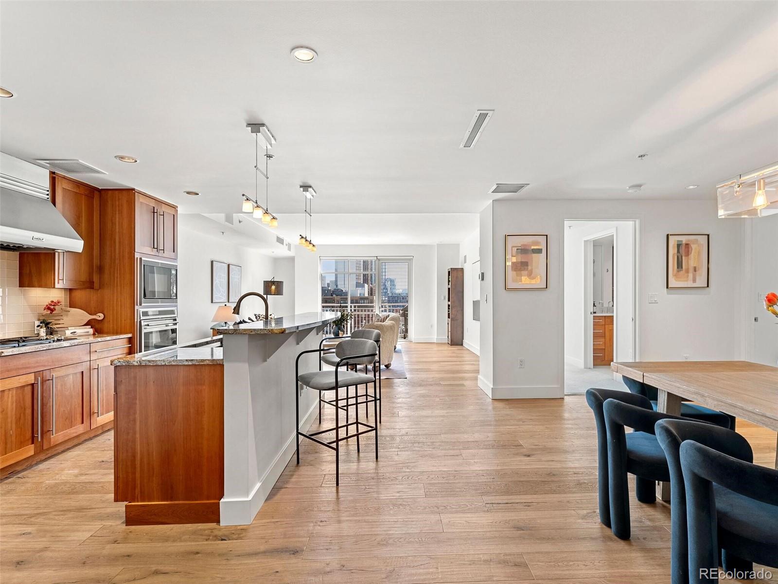 a view of a dining room and livingroom with furniture wooden floor a chandelier