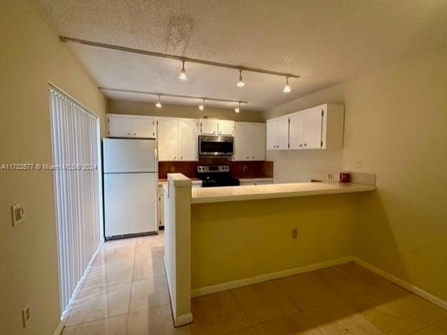 a view of a kitchen with a sink and a refrigerator