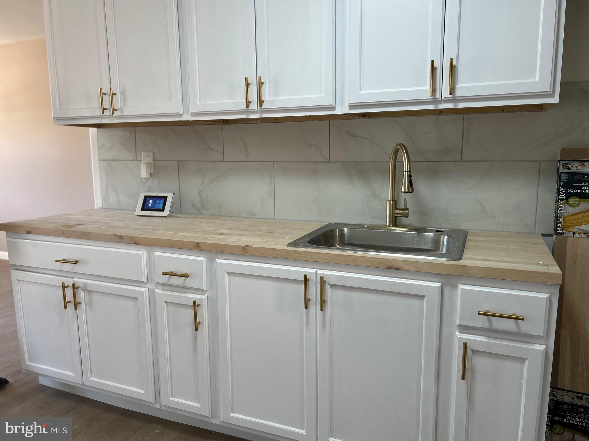 a kitchen with white cabinets and a sink