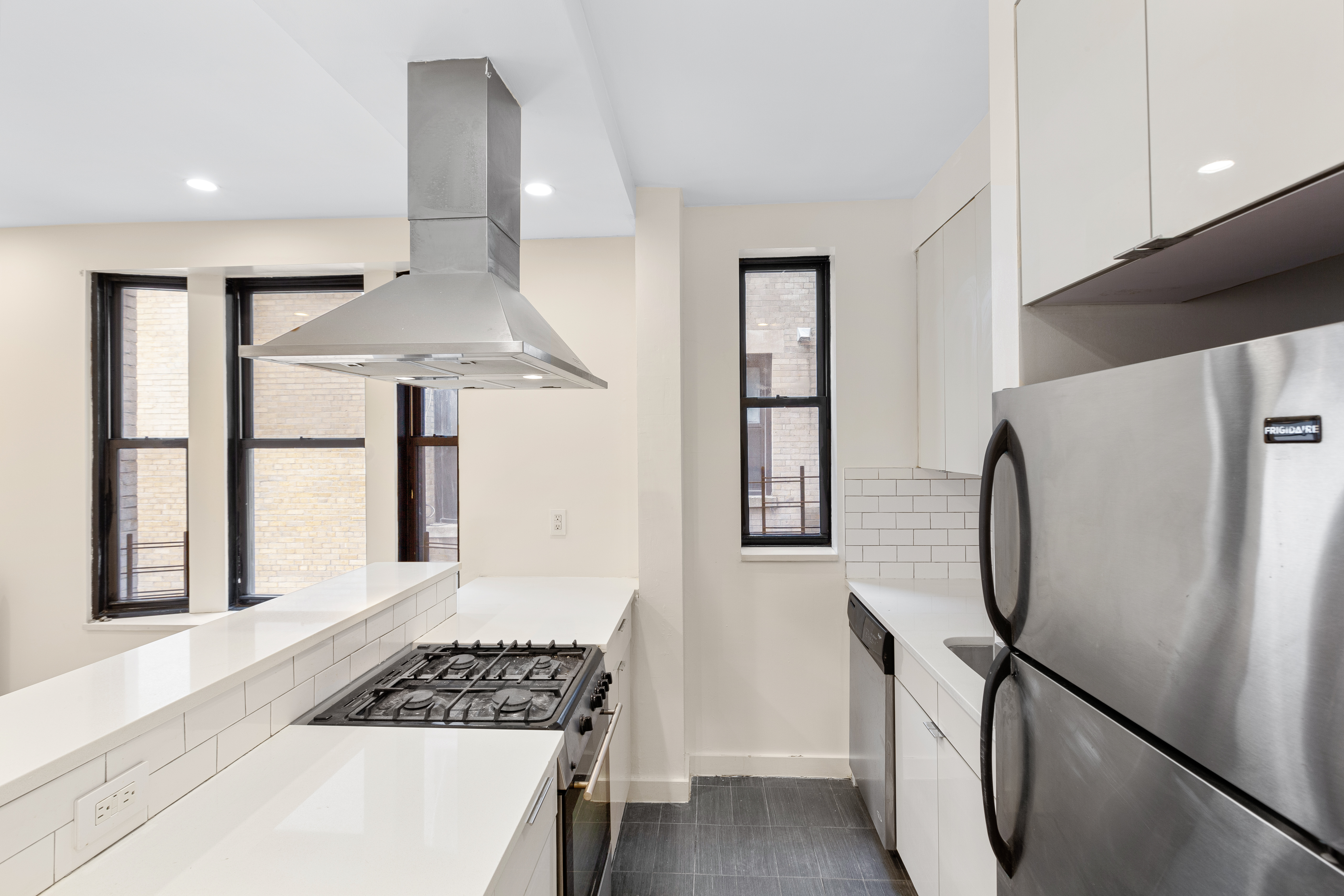 a kitchen with stainless steel appliances granite countertop a refrigerator and a stove top oven