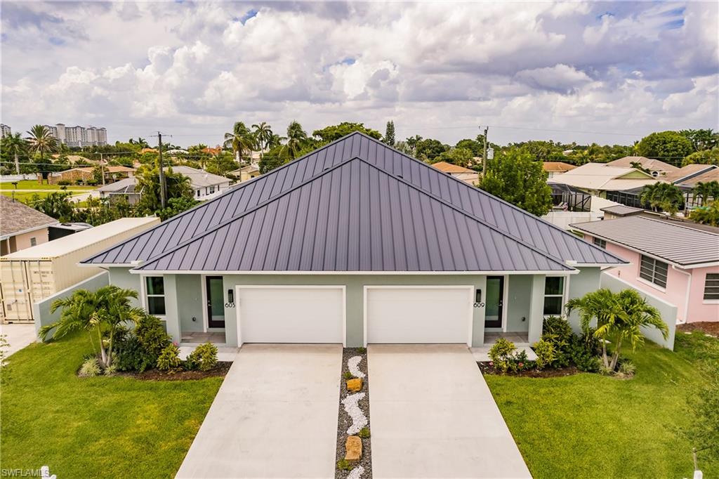 a aerial view of a house with a yard plants and large tree