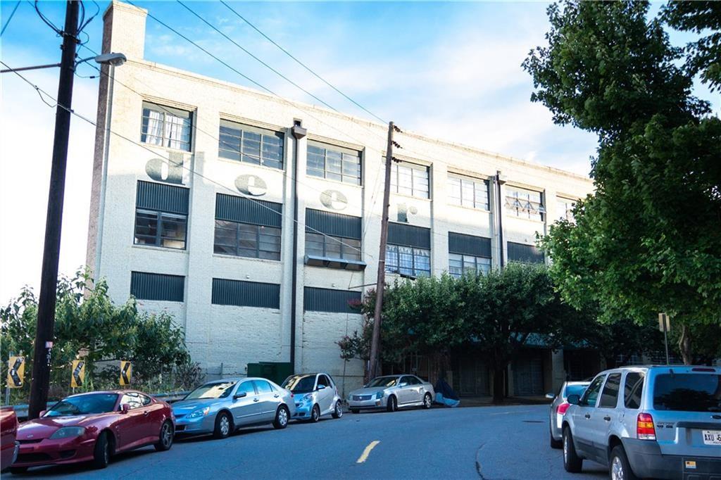 a view of a cars park in front of a building