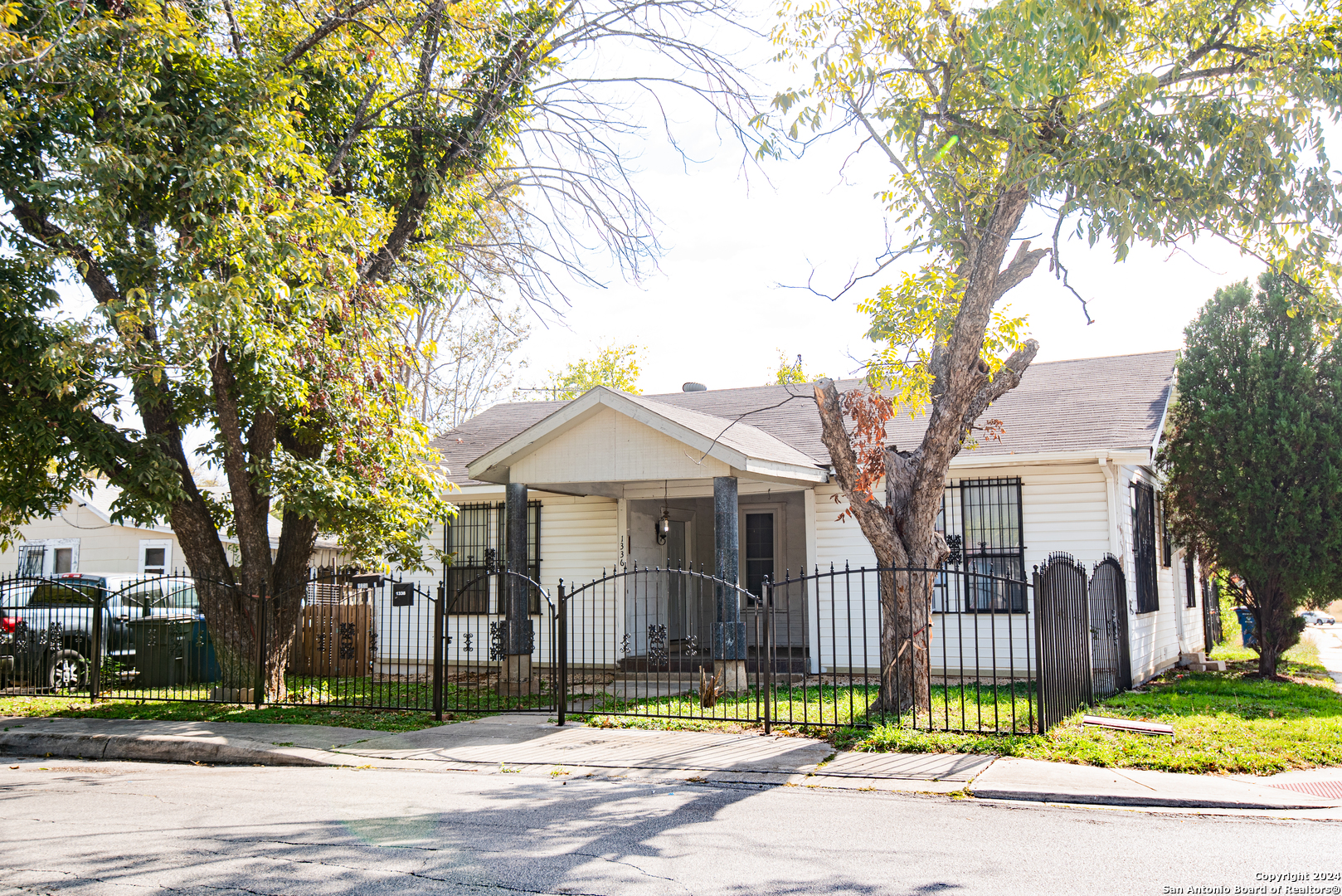 a front view of a house with a garden and tree