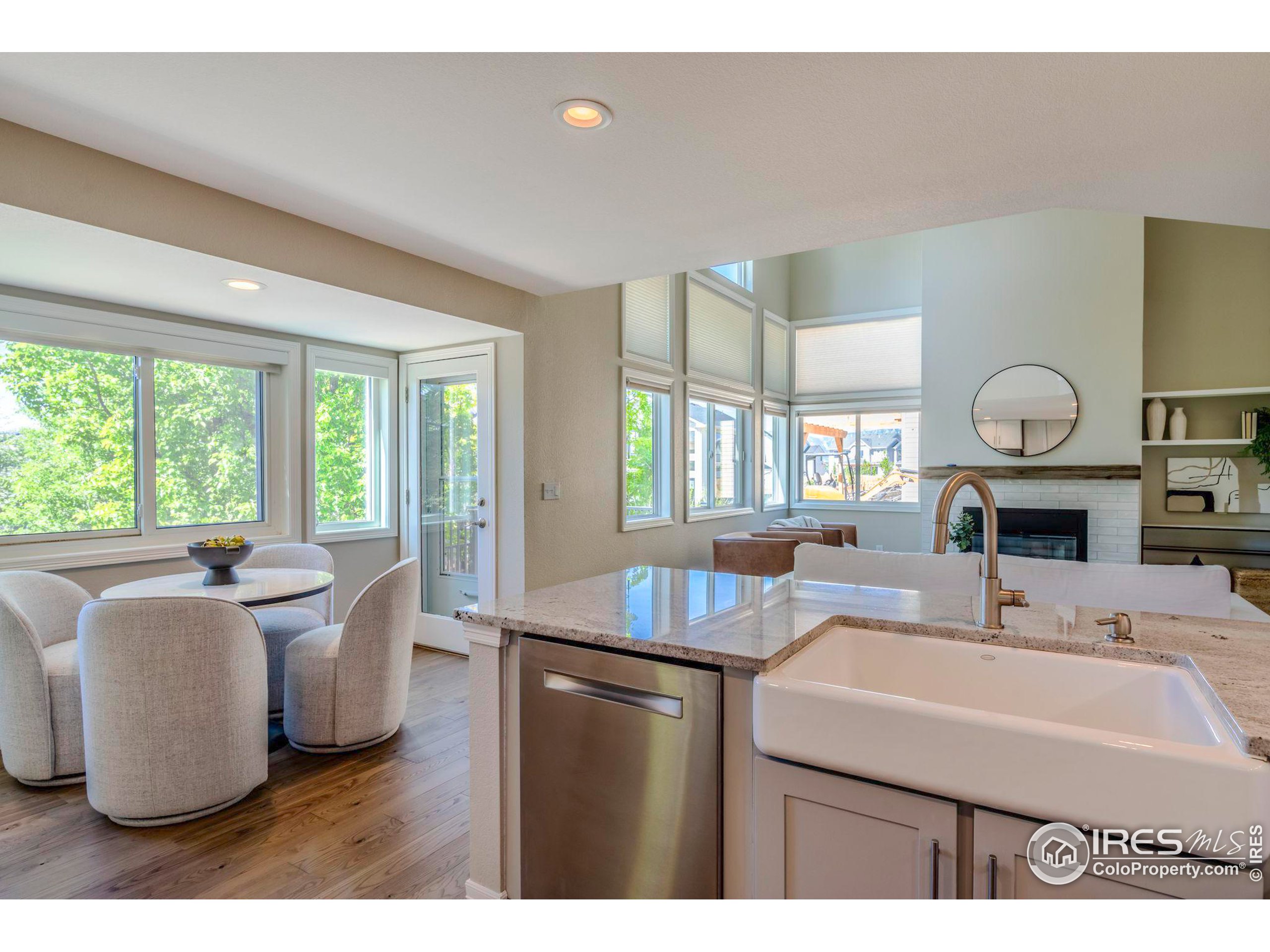 a living room with kitchen island furniture a fireplace and a large window