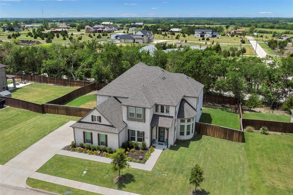 an aerial view of residential houses with outdoor space and trees