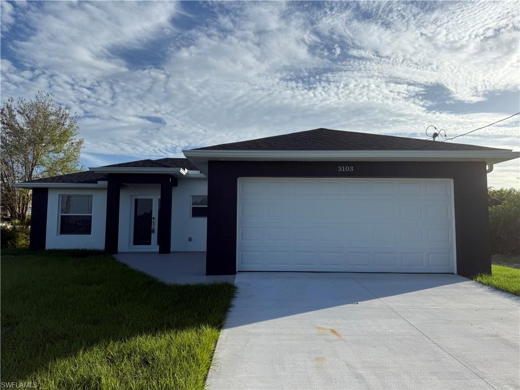 a front view of a house with a yard and garage