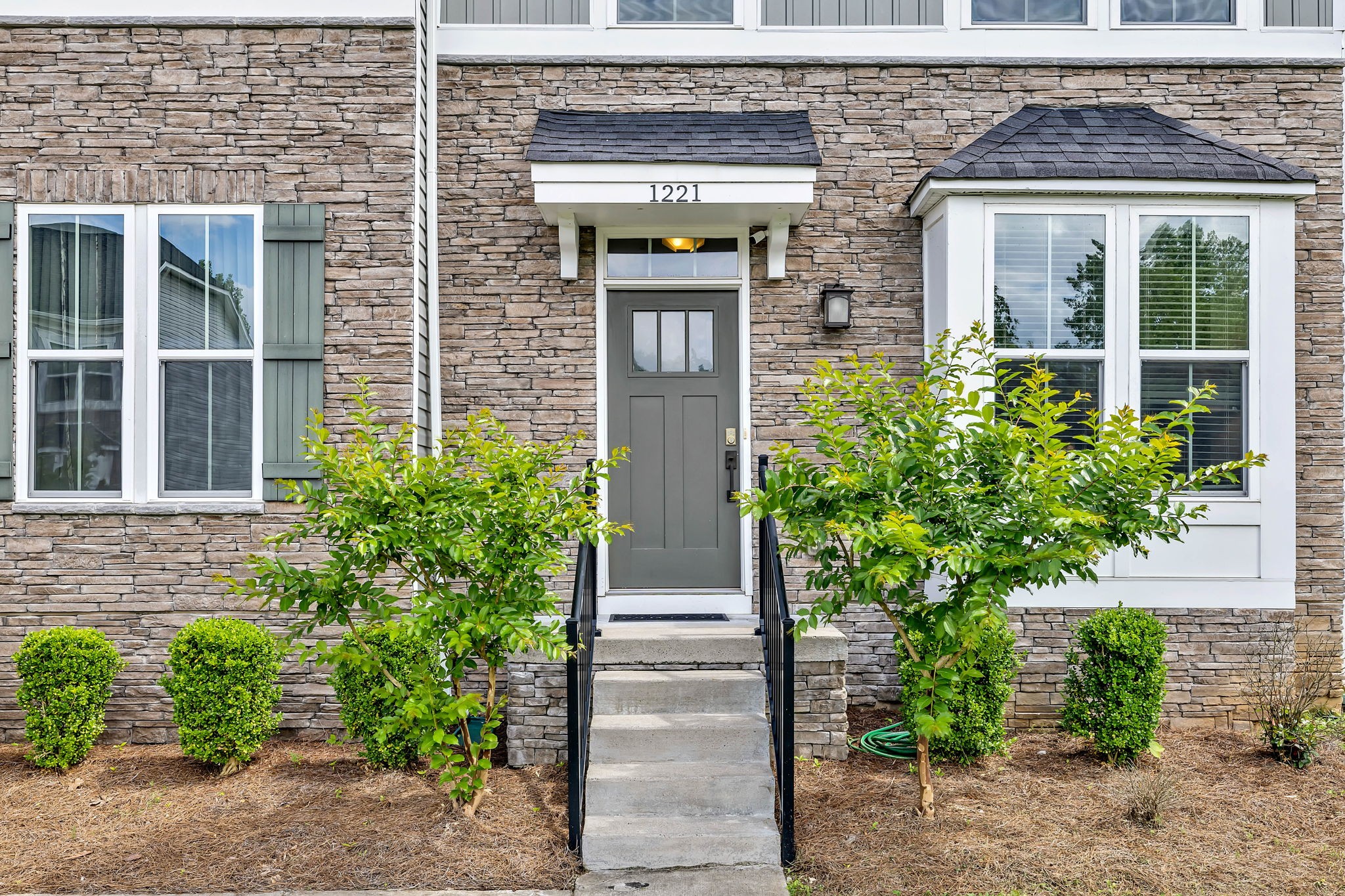 front view of a brick house with potted plants