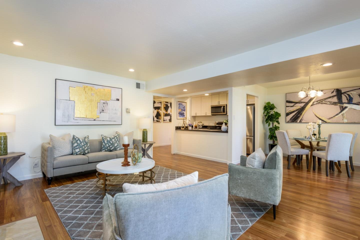 a living room with furniture and a dining table with wooden floor