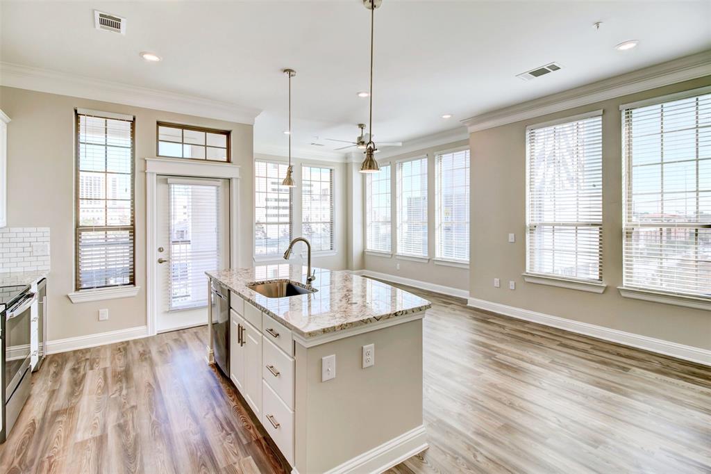 a spacious kitchen with stainless steel appliances granite countertop a sink and wooden floors