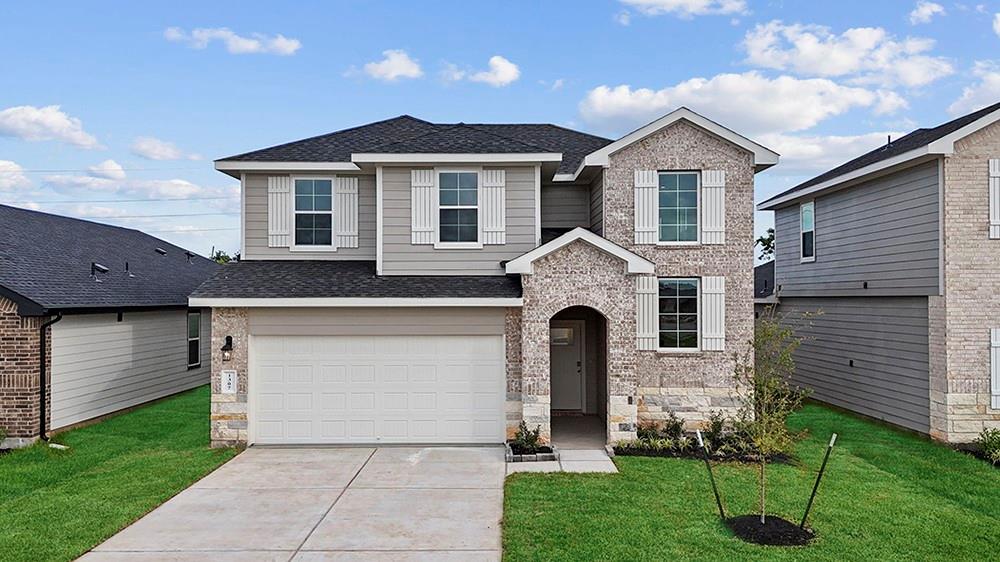 a front view of a house with a yard and garage