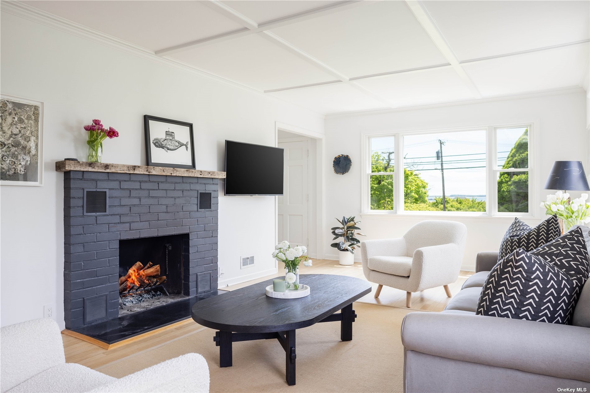 a living room with furniture a fireplace and a large window