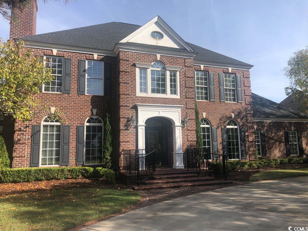 Colonial-style house with a front lawn