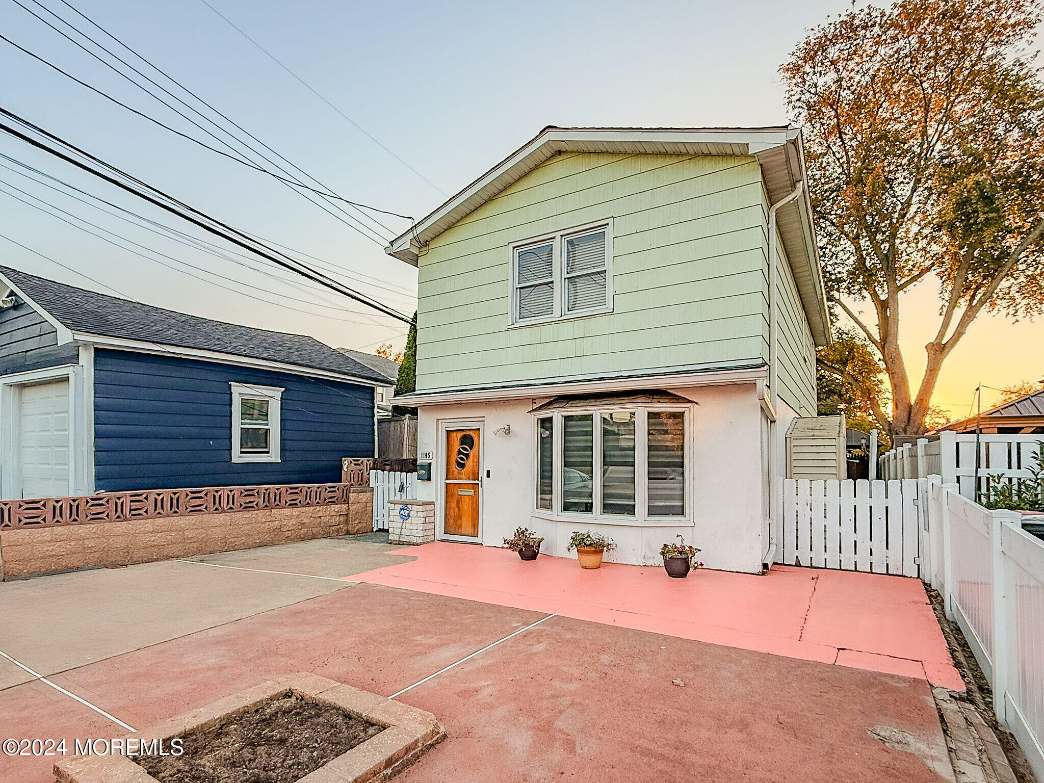 a backyard of a house with barbeque oven and wooden fence