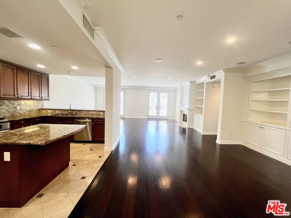 a kitchen with stainless steel appliances granite countertop a sink stove and wooden floor