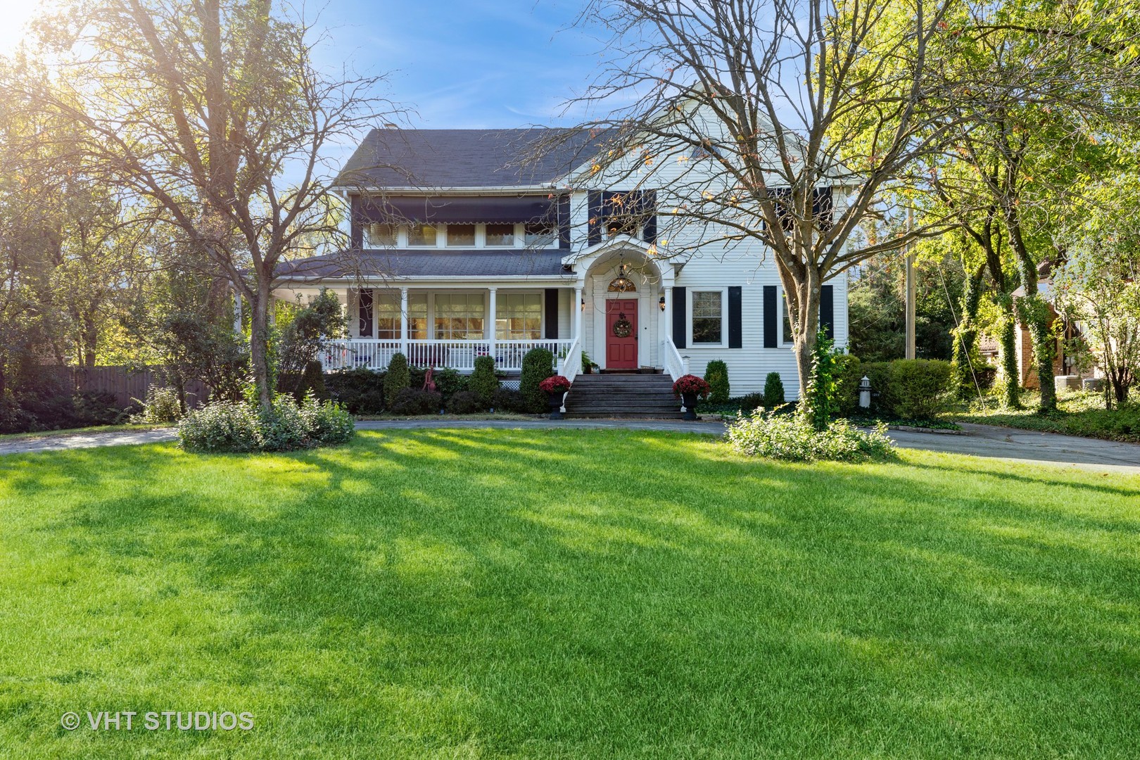 a front view of a house with a garden and trees